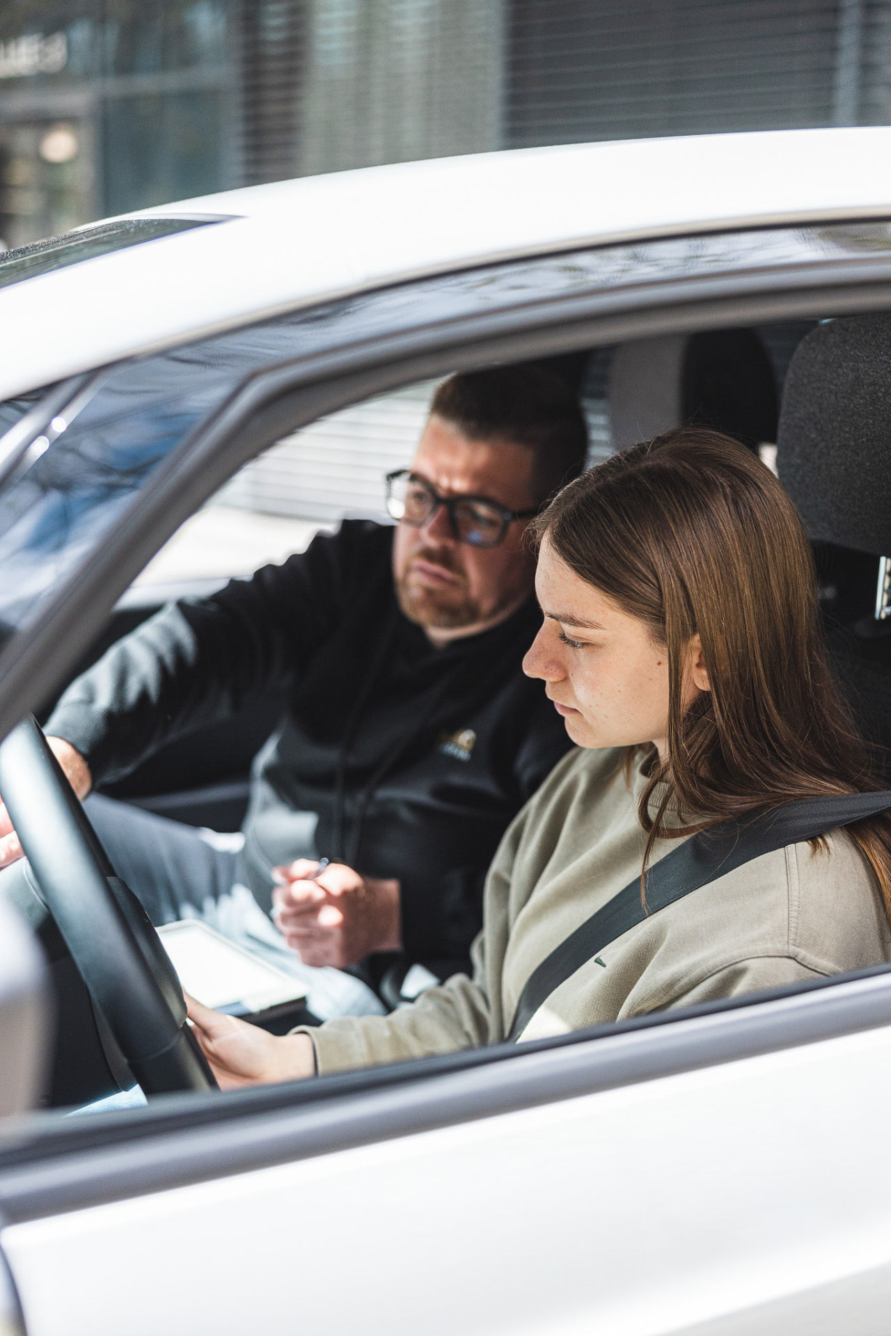 Lernende und Fahrlehrer im Auto während einer Fahrstunde in Bern